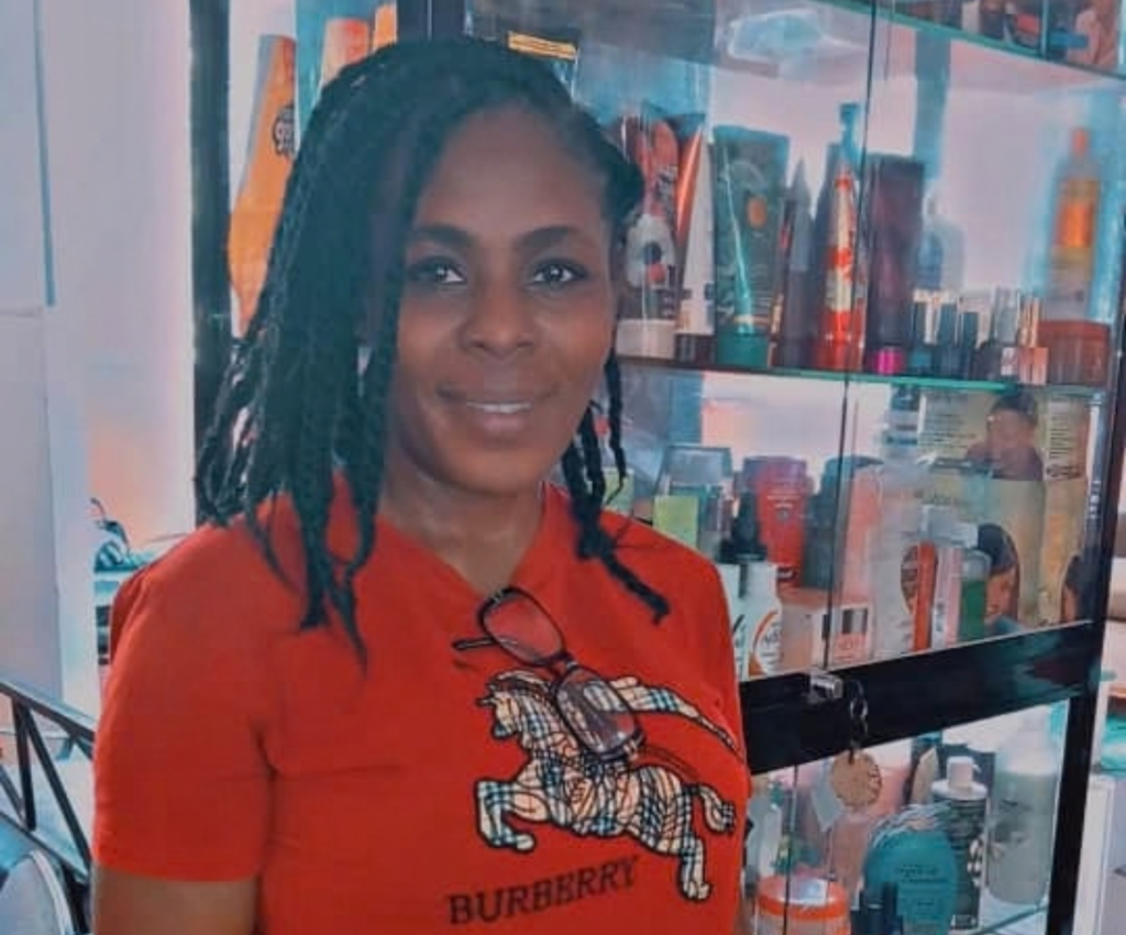Une entrepreneure haïtienne pose dans son salon de beauté
